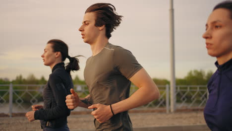 Un-Joven-Y-Dos-Mujeres-Corren-Juntos-En-Verano-Entrenando-Y-Trotando